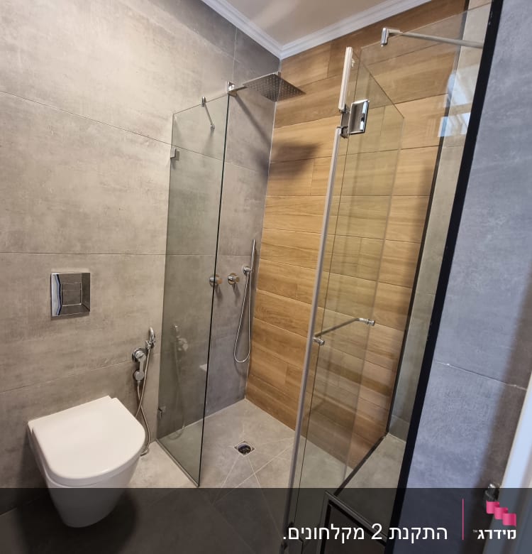 מקלחון זכוכית עם ראש מקלחת מרובע על קיר עץ